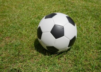 Çimenlerin üzerine konulmuş siyah beyaz klasik bir futbol topu.