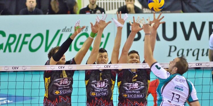 File önünde smaç vuran voleybolcular ve yükselen sarı mavi voleybol topu.