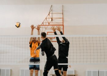 Salonda file önünde karşılıklı voleybol oynayan sporcuların heyecanlı mücadelesi.