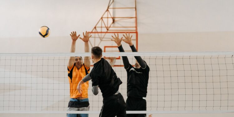 Salonda file önünde karşılıklı voleybol oynayan sporcuların heyecanlı mücadelesi.