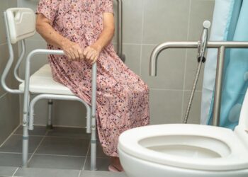 Hastane banyosunda özel tutunma barları bulunan tuvalet ve duş oturacağı.