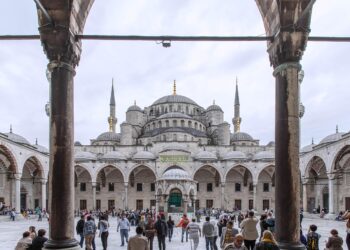 Sultanahmet Camii avlusunda dolaşan insanlar ve avlu ortasındaki şadırvan