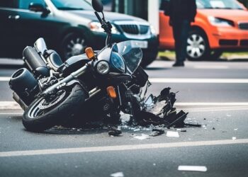 Yol ortasında ağır hasar almış ve parçalanmış siyah bir motosiklet