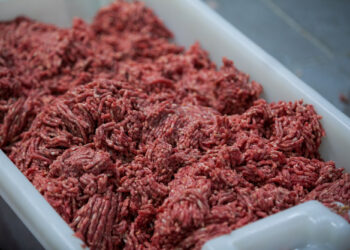 Beyaz plastik kasada taze çekilmiş kırmızı kıyma eti bulunuyor.