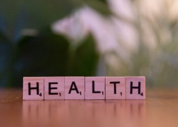 Ahşap harf bloklarıyla masada yan yana dizilmiş HEALTH kelimesi.