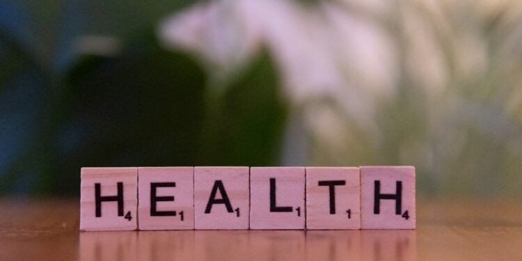 Ahşap harf bloklarıyla masada yan yana dizilmiş HEALTH kelimesi.