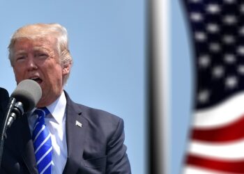 Mikrofona konuşan ve yumruğunu havaya kaldıran Donald Trump