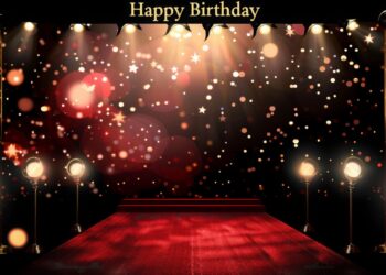 Kırmızı halıyla kaplı, sahne ışıkları ve Happy Birthday yazısı bulunan kutlama alanı.